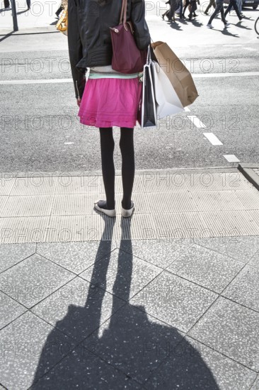 DEU Germany Germany Berlin A woman with shopping bags waits at a pedestrian traffic light on Potsdamer Platz