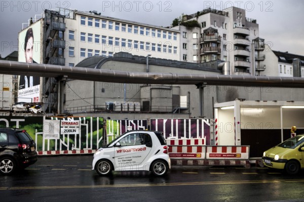 DEU Germany Germany Berlin A smart with the inscription 'economic miracle' in front of a construction site at the memorial church