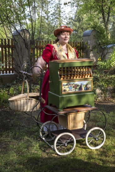 DEU Germany Germany Berlin An organ box woman plays for wedding guests during a reception in the garden