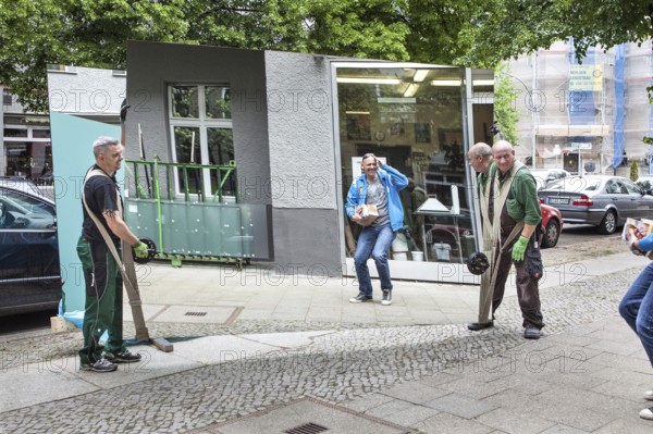 DEU Germany Germany Berlin A local resident looks at himself in a huge mirror that is being transported by two glaziers