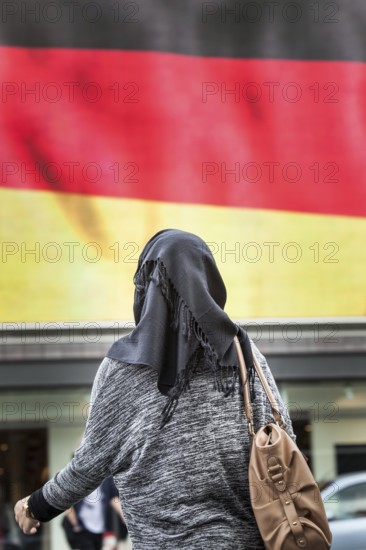 DEU Germany Germany Berlin Passers-by in front of a projection screen on Kurfürstendamm, on which a commercial featuring a large German flag is being broadcast