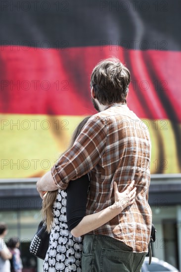 DEU Germany Germany Berlin Passers-by in front of a projection screen on Kurfürstendamm, on which a commercial featuring a large German flag is being broadcast