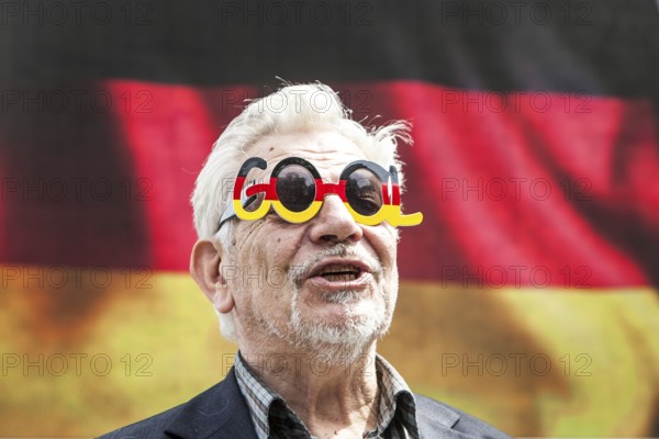 DEU Germany Germany Berlin Passers-by in front of a projection screen on Kurfürstendamm, on which a commercial featuring a large German flag is being broadcast