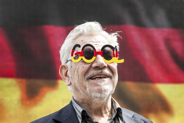 DEU Germany Germany Berlin Passers-by in front of a projection screen on Kurfürstendamm, on which a commercial featuring a large German flag is being broadcast