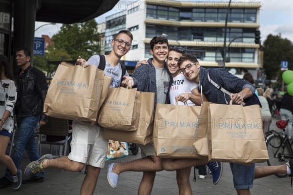 DEU Germany Germany Berlin Young Italian tourists pose with their Primark bags on Schlossstraße in Steglitz