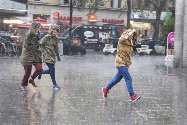 DEU Germany Germany Berlin Young woman running through the rain