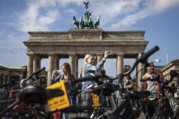 DEU Germany Germany Berlin Tourists take selfies in front of the Brandenburg Gate with their smartphones