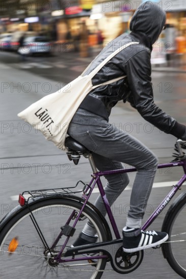 DEU Germany Germany Berlin female cyclist with cloth bag crosses a street in the capital