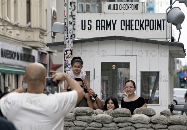 Tourists take a souvenir photo at Checkpoint Charlie, Berlin, Germany