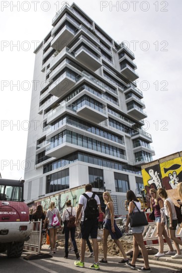 DEU Germany Germany Berlin Tourists pass through the opening in the East-Side Gallery, which was built for a new building. The removal of the piece of wall for the construction of the luxury property directly on the Spree behind the wall led to fierce protests among the population