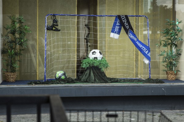 DEU Germany Germany Berlin Display of a discount funeral home on Bundesallee. Ball as an urn for the soccer fan from Hertha BSC Berlin