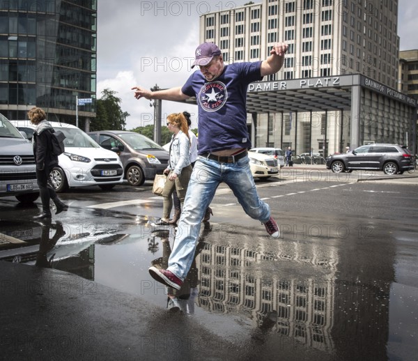 DEU Germany Germany Berlin Pedestrians jump over a cap at Potsdamer Pltz