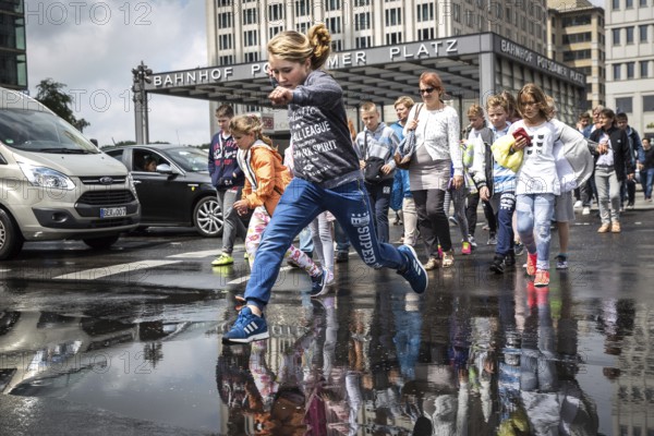DEU Germany Germany Berlin Pedestrians jump over a cap at Potsdamer Pltz