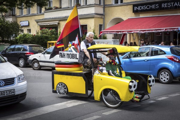 DEU Germany Germany Berlin A man drives through Schöneberg in a self-made European championship fanmobile, a bicycle rickshaw. The van can be rented
