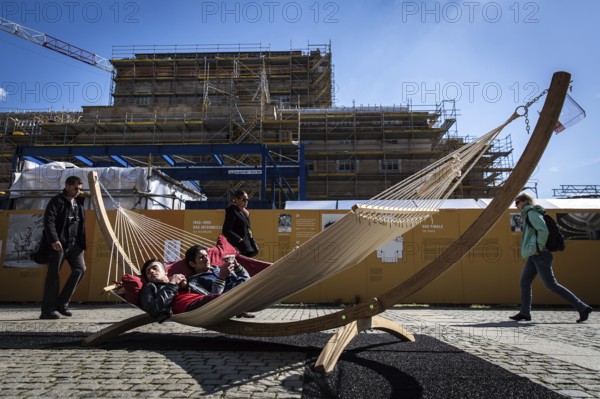 DEU Germany Germany Berlin Tourists sunbathe in a hammock not far from the Staatsoper Unter den Linden during a 'Book Day' exhibition on Bebelplatz