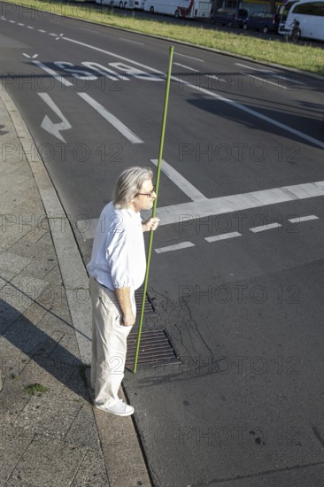 DEU Germany Germany Berlin A man stands with a green pole at a pedestrian traffic light