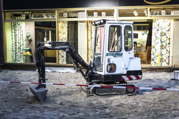 DEU Germany Germany Berlin A small excavator stands in front of an interior decoration shop