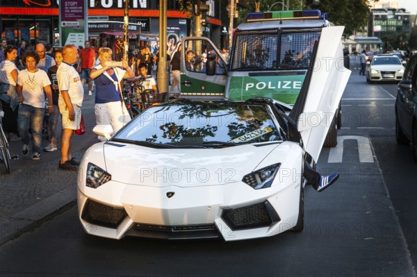 DEU Germany Germany Berlin A Lamborghini sports car is observed or photographed by passers-by on the Tauentzien. The driver got into a police checkpoint. Young people admire the luxury car from a distance
