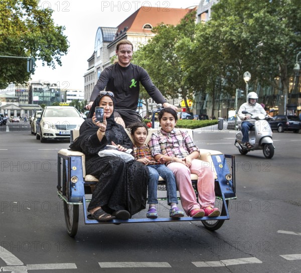 DEU Germany Germany Berlin A woman rides over Tauentzien in a rickshaw with her children