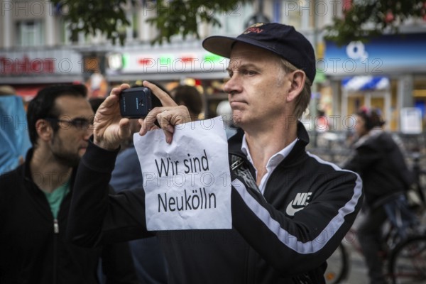 DEU Germany Germany Berlin Protest rally against intolerance of wearing headscarves and the ban on working and discrimination against woman wearing headscarves on City Hall Square in Berlin-Neukölln. Man photographed with poster 'Wir sind Neukölln'