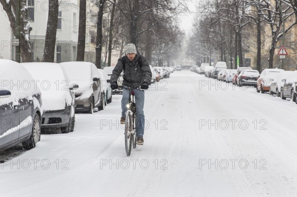 DEU Germany Germany Berlin Cyclists on snow-covered road in Schöneberg