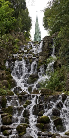 Artificial waterfall in Victoria Park, with the national monument on Kreuzberg in the background, Berlin-Kreuzberg, Germany