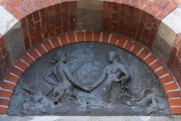 Lighthouse, access to the Kiel Canal, NOK, relief above the front door, symbol, mermaids of the North Sea and Baltic Sea shake hands, fishing net, fish, water, semicircle, lake ponds, Kiel Fjord, Holtenau district, Schleswig-Holstein, Germany