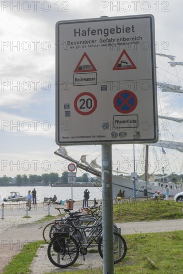 Warning of flood risk in port area, sign, special danger area, stopping ban, speed limit, 20 km/h zone, traffic sign, three-master, Kiel Canal, bicycles, people, Baltic Sea, Kiel Fjord, Kiel, Holtenau district, Schleswig-Holstein, Germany