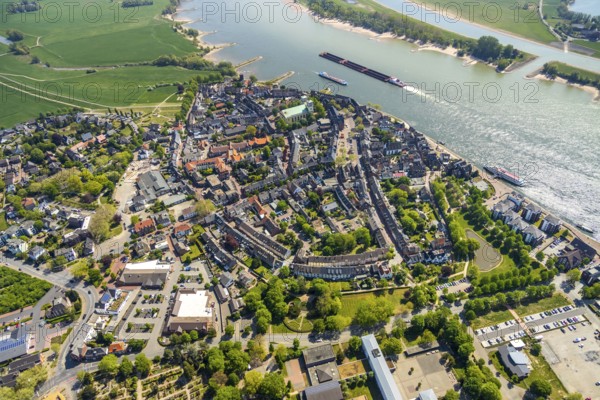 Aerial view, town view Rees, river Rhine, catholic church St. Assumption of the Virgin Mary, Rheinterrassen Rees, Rhine promenade, Rees, Lower Rhine, North Rhine-Westphalia, Germany, excursion boat, DE, Europe, distant view, property tax, real estate, Kalkar, cargo ships, aerial view, aerial photography, aerial photography, shipping, shipping pier, shipping traffic, overview, bird's eye view, meadows and fields, residential area, living and life, residential area, residential buildings, residential quality, housing estate, birds-eyes view, overview