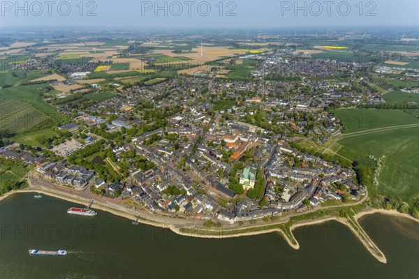 Aerial view, town view Rees, river Rhine, catholic church St. Assumption of the Virgin Mary, Rheinterrassen Rees, Rhine promenade, Rees, Lower Rhine, North Rhine-Westphalia, Germany, excursion boat, DE, Europe, distant view, property tax, real estate, Kalkar, cargo ships, aerial view, aerial photography, aerial photography, shipping, shipping pier, shipping traffic, overview, bird's eye view, meadows and fields, residential area, living and life, residential area, residential buildings, residential quality, housing estate, birds-eyes view, overview
