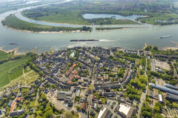 Aerial view, city centre view, catholic church St. Mariä Himmelfahrt, river Rhine, sports harbour Obermörmter, Reeser Schanz landscape protection area, shipping, Rees, Lower Rhine, North Rhine-Westphalia, Germany, place of worship, DE, Europe, religious community, place of worship, goods transport, goods traffic, harbour, church, parish, denomination, cargo ships, logistics, aerial view, aerial photography, aerial photography, religion, Rhine bend, shipping traffic, overview, bird's eye view, birds-eyes view, overview