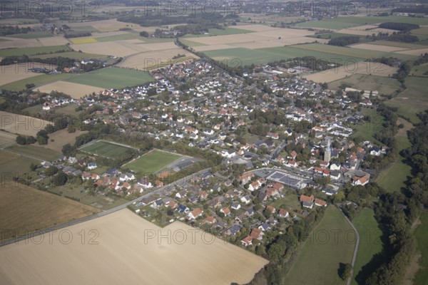 Aerial view, view of the town, St. Stephanus Kirche, Oestinghausen, Lippetal, Kreis Soest, North Rhine-Westphalia, Germany, Aldi Supermarkt Neubau, Andachtstätte, DE, Europa, Fußballplatz, Fußballstadion, Fußballverein, Glaubensgemeinschaft, Gotteshaus, Grundsteuer, Immobilien, Kirche, Kirchengemeinde, Konfession, Kreis-Soest-Buch, KreisSoestBuch, aerial view, aerial photography, aerial photography, religion, sports, sports facilities, sports field, sports facility, stadium, townscape, urban area, overview, bird's-eye view, meadows and fields, residential area, housing and living, residential area, residential buildings, residential quality, residential neighbourhood, housing estate, birds-eyes view, overview