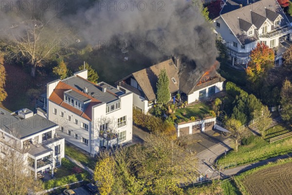 Several callers reported a fire with heavy smoke on Bergerstraße in Mülheim-Menden at 2.57 pm today, Saturday. When the first emergency services arrived, they discovered that the roof truss of a two-storey residential building was fully engulfed in flames. Due to the expected long and intensive operation, a full alarm was immediately sounded for the volunteer fire brigade. There were no residents in the house. Firefighters from the professional fire brigade immediately began fighting the fire from the inside and using a turntable ladder. As the operation progressed, they were supported by colleagues from the Heißen fire brigade of the volunteer fire brigade. Once the actual fire had been extinguished, the post-extinguishing work proved to be quite complex and lengthy. Parts of the roof have to be removed in order to reach any remaining embers. The ongoing operation involved two fire engines, several special and command vehicles from the professional fire brigade as well as vehicles fro...