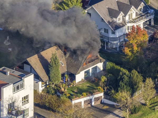 Several callers reported a fire with heavy smoke on Bergerstraße in Mülheim-Menden at 2.57 pm today, Saturday. When the first emergency services arrived, they discovered that the roof truss of a two-storey residential building was fully engulfed in flames. Due to the expected long and intensive operation, a full alarm was immediately sounded for the volunteer fire brigade. There were no residents in the house. Firefighters from the professional fire brigade immediately began fighting the fire from the inside and using a turntable ladder. As the operation progressed, they were supported by colleagues from the Heißen fire brigade of the volunteer fire brigade. Once the actual fire had been extinguished, the post-extinguishing work proved to be quite complex and lengthy. Parts of the roof have to be removed in order to reach any remaining embers. The ongoing operation involved two fire engines, several special and command vehicles from the professional fire brigade as well as vehicles fro...