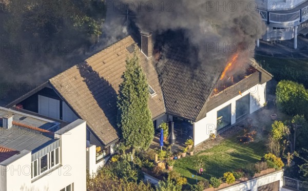 Several callers reported a fire with heavy smoke on Bergerstraße in Mülheim-Menden at 2.57 pm today, Saturday. When the first emergency services arrived, they discovered that the roof truss of a two-storey residential building was fully engulfed in flames. Due to the expected long and intensive operation, a full alarm was immediately sounded for the volunteer fire brigade. There were no residents in the house. Firefighters from the professional fire brigade immediately began fighting the fire from the inside and using a turntable ladder. As the operation progressed, they were supported by colleagues from the Heißen fire brigade of the volunteer fire brigade. Once the actual fire had been extinguished, the post-extinguishing work proved to be quite complex and lengthy. Parts of the roof have to be removed in order to reach any remaining embers. The ongoing operation involved two fire engines, several special and command vehicles from the professional fire brigade as well as vehicles fro...