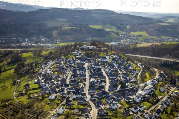 Aerial view, view of Eversberg, ruins of Eversberg Castle, Schlossberghalle Eversberg, St.-Johannes-Evangelist-Kirche, Eversberg, Meschede, Sauerland, North Rhine-Westphalia, Germany, castle, DE, Europe, half-timbered houses, religious community, place of worship, property tax, hilly landscape, real estate, church, parish, denomination, aerial view, aerial photography, aerial photography, Arnsberg Forest nature park Park, religion, ruins, castle, castle hill, overview, event location, event venue, bird's-eye view, meadows and fields, residential area, living and life, residential area, residential buildings, residential quality, residential neighbourhood, housing estate, bird's-eye view, cultural use, overview
