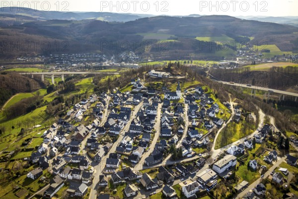 Aerial view, view of Eversberg, ruins of Eversberg Castle, Schlossberghalle Eversberg, St.-Johannes-Evangelist-Kirche, Eversberg, Meschede, Sauerland, North Rhine-Westphalia, Germany, castle, DE, Europe, half-timbered houses, religious community, place of worship, property tax, hilly landscape, real estate, church, parish, denomination, aerial view, aerial photography, aerial photography, Arnsberg Forest nature park Park, religion, ruins, castle, castle hill, overview, event location, event venue, bird's-eye view, meadows and fields, residential area, living and life, residential area, residential buildings, residential quality, residential neighbourhood, housing estate, bird's-eye view, cultural use, overview