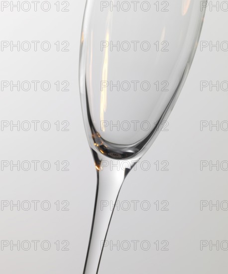 Studio photography of a champagne glass detail with warm light reflections