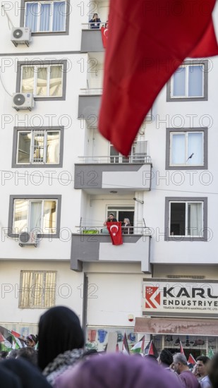 Gaziantep, Türkiye – October 11, 2025: People watch and show support from their balconies as thousands march in a massive rally in solidarity with Gaza, following the announcement of a ceasefire, the withdrawal of Israeli forces, and a prisoner exchange between Hamas and Israel, Gaziantep, Türkiye