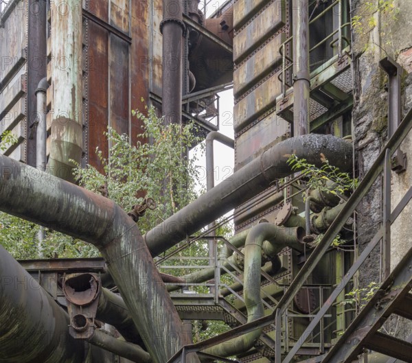 Weathered rundown industrial scenery with old corroded steel girders and metal tubes
