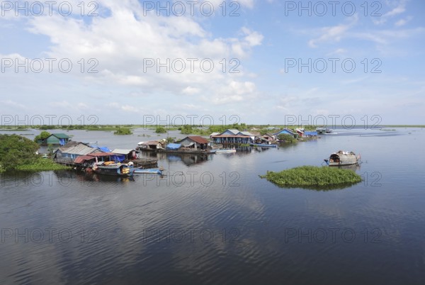 Waterside scenery with rural houses and boats at the Tonle Sap, a river in Cambodia