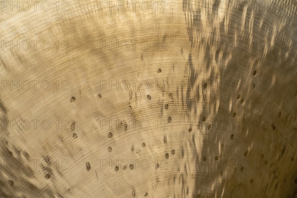 Full frame abstract closeup shot of a metallic asian gong