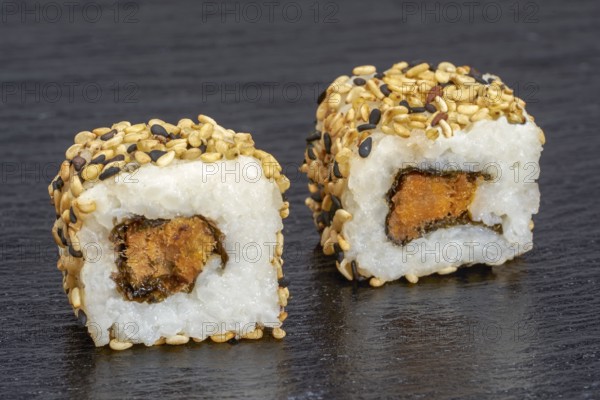 Two sushi dish on dark grey stone surface