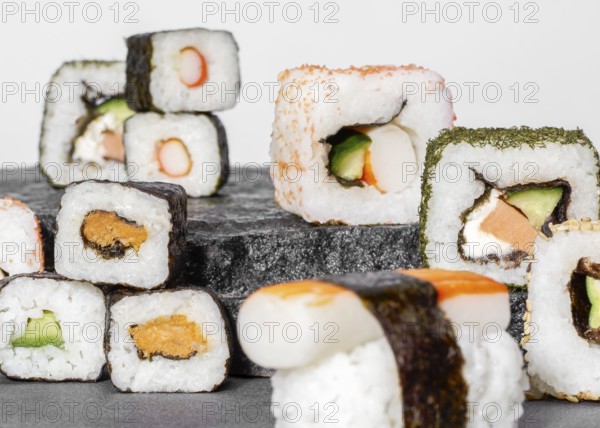 Various sushi dishes on dark grey stone surface