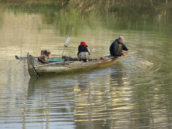 Riparian scenery with small boat at a river in Cambodia