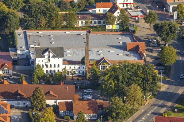 Aerial photograph, WEZ supermarket, stork's nest on the chimney of the Alte Kornbrennerei, Hille, Ostwestfalen-Lippe, OWL, North Rhine-Westphalia, Germany, Alte Brennerei, DE, shopping square, shopping centre, Europe, Hillerichs, industrial museum, Kornbrennerei Meyer, aerial photograph, aerial photography, aerial photography, Mindener Straße, museum, local shopping centre, nest, OWL book, OWLBuch, Ostwestfalenbuch, chimneys, shopping centre, StorchenLeben, supermarket, tower, overview, bird's-eye view, white storks, birds-eyes view, overview