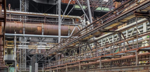 Weathered rundown industrial scenery with old corroded steel girders and metal tubes