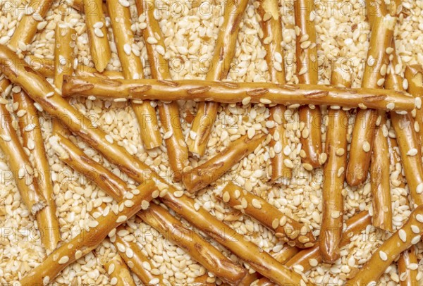 Full frame closeup of some baked sesame sticks in sesame back