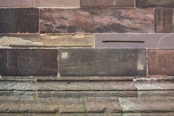 Historic engravings on a stone wall at the Freiburg Minster in Freiburg im Breisgau, a city in southern German