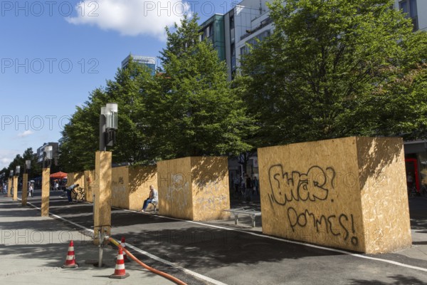 DEU Germany Germany Berlin View of the pedestrian zone on Wilmersdorfer Strasse, where the trees are covered with wood to protect them due to construction work